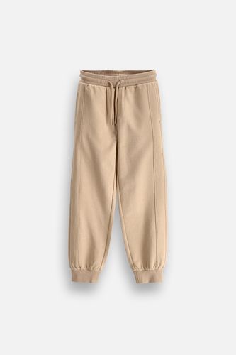 COCCODRILLO COCCODRILLO Spodnie dresowe JOGGER beżowe z wiązaniem w pasie o fasonie SLIM rozmiar 104 dla chłopca